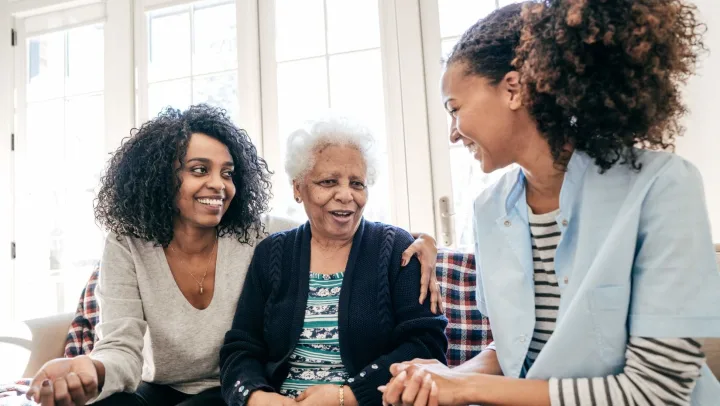 two younger girls with one elderly woman smiling